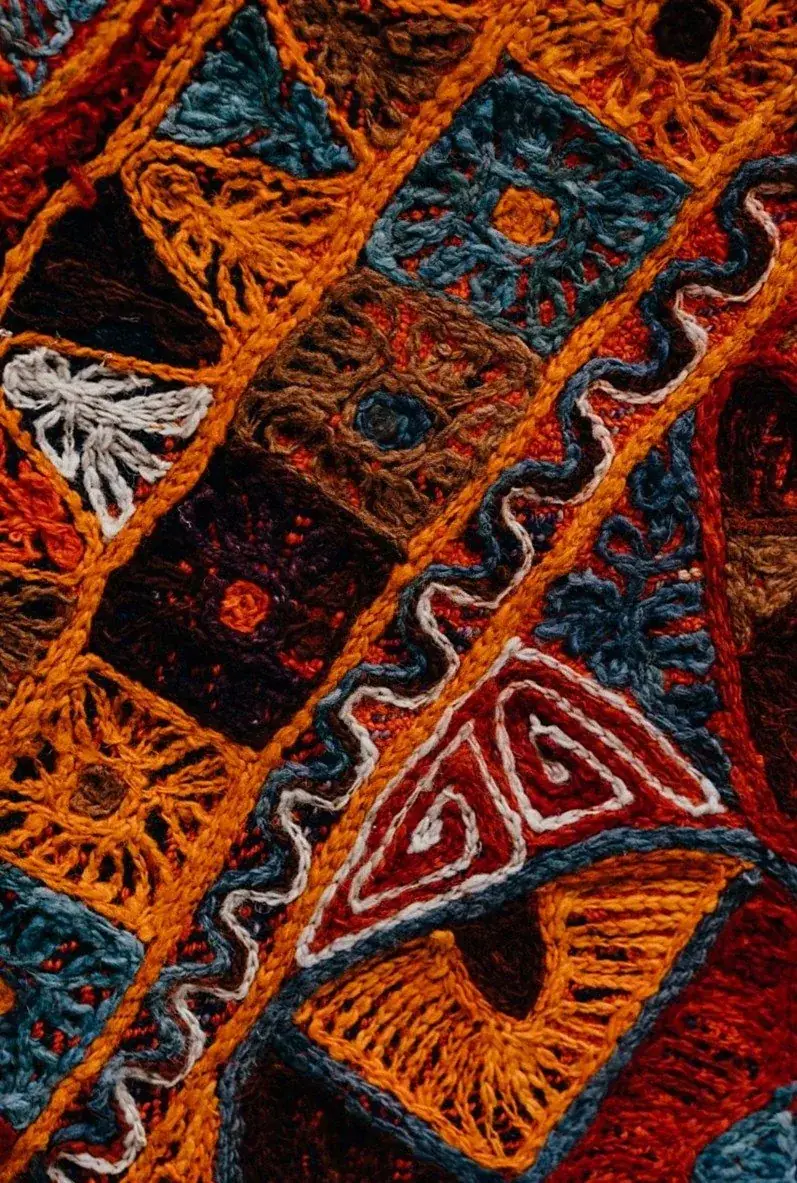 オレンジと紺の糸で刺した幾何学模様の刺繍布