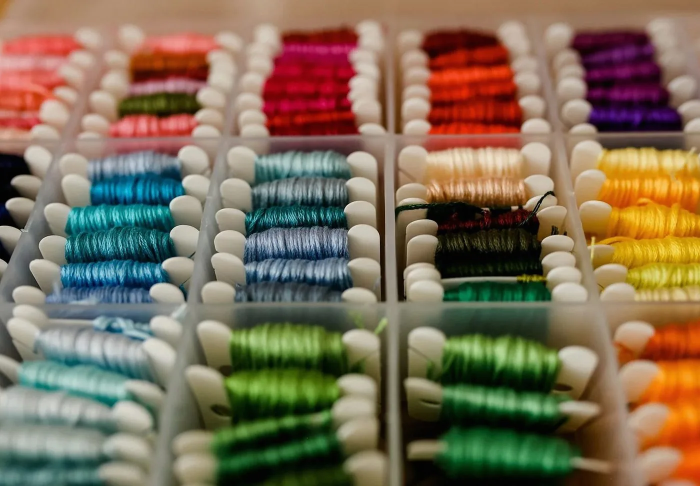 仕切り箱に色ごとに並べた刺繍糸
